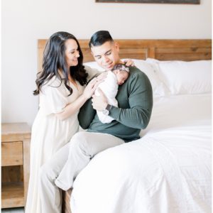 A couple holding their newborn in a bedroom