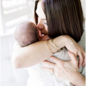 A woman kissing an infant