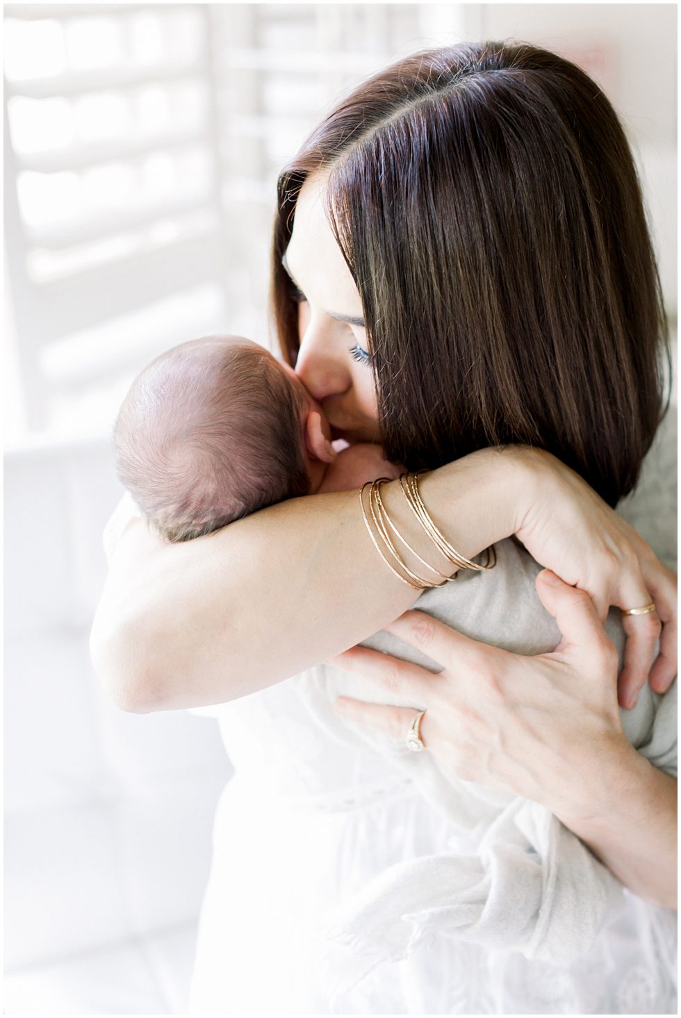 A woman kissing an infant