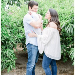 A couple in denim jeans holding their newborn